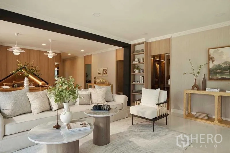 Detached House for sale in Bang Phli, Samut Prakan - Bright living room with L-shaped sofa, built-in shelving and coffee tables facing the dining area.