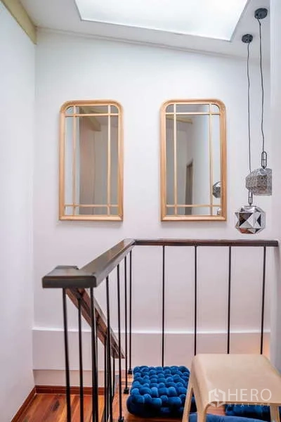 Townhouse for rent in Khlong Toei, Bangkok - Stair landing with skylight, decorative mirrors and pendant lighting.