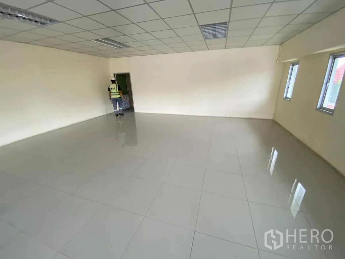Factory for rent in Khlong Toei, Bangkok - Empty office suite with tiled flooring and windows for natural light.