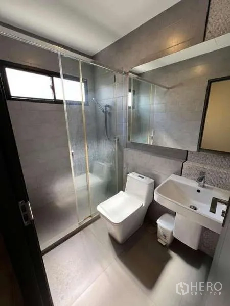 Detached House for rent or sale in Bang Phli, Samut Prakan - Third bathroom with grey tiling, glass shower and large mirror.