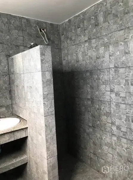 联排别墅 出租在Suan Luang, Bangkok - 步入式淋浴区，灰色瓷砖与半高隔墙。