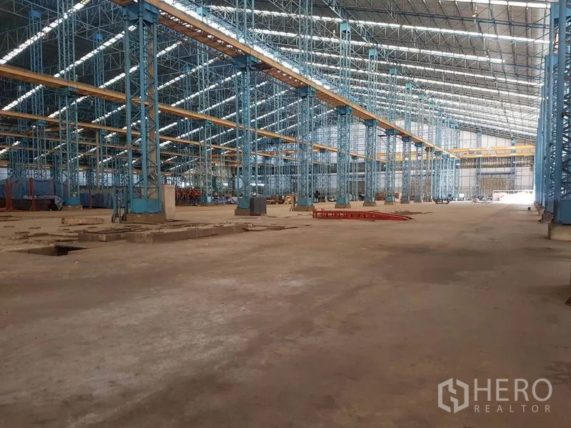 Factory for rent in Mueang Samut Sakhon, Samut Sakhon - Vast factory hall with high steel structure, skylights, and crane girders over open production space.