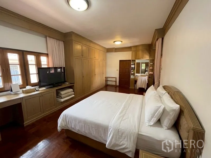 Detached House for sale in Suan Luang, Bangkok - Spacious bedroom with extensive built-in wardrobes and TV unit.