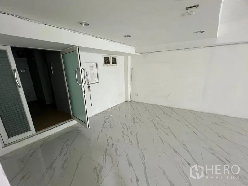 Retail Space for rent in Khlong Toei, Bangkok - Compact back room with frosted sliding doors and marble-look flooring.