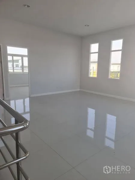 Factory for rent or sale in Lam Luk Ka, Pathum Thani - Upper-floor hall with stainless railings and tall windows.