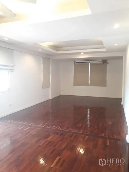 Detached House for rent in Watthana, Bangkok - Spacious room with recessed ceiling, hardwood floors, window blinds and wall air conditioner