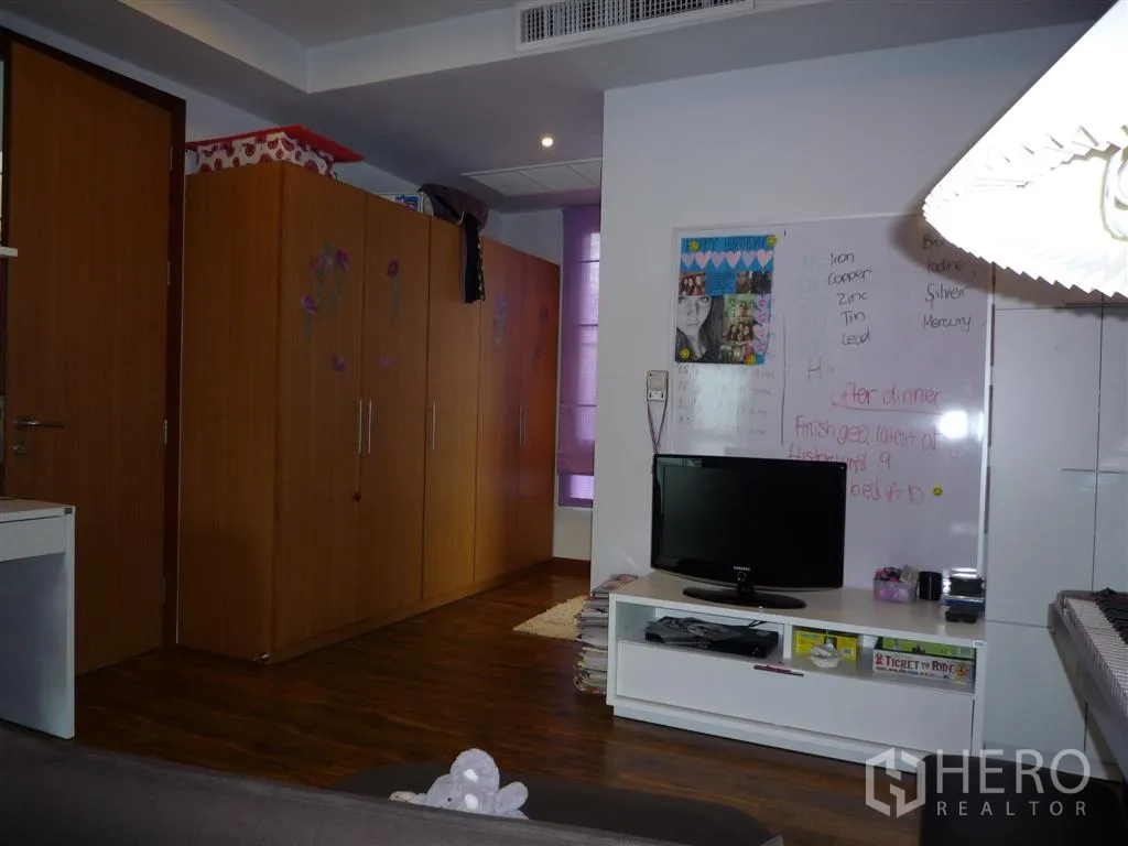 Detached House for rent in Khan Na Yao, Bangkok - Room with built-in wardrobes, TV stand and whiteboard on wooden flooring.