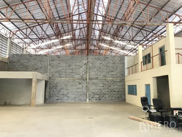 Warehouse for rent in Khlong Sam Wa, Bangkok - Spacious warehouse interior with high steel truss roof, skylights, brick partition wall and open clear-span floor.