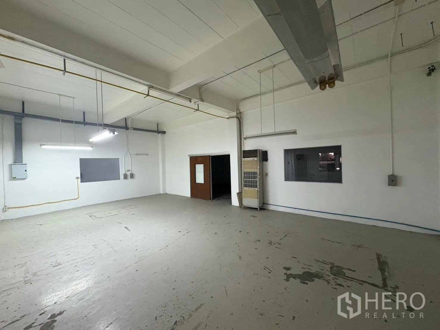 Warehouse for rent in Bang Phli, Samut Prakan - Open-plan workspace with service window and suspended lights.