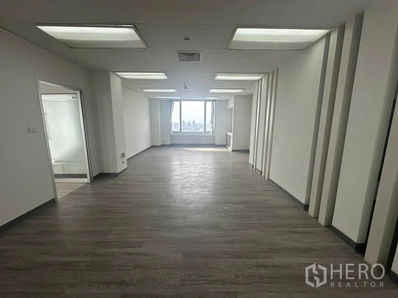 Office Space for rent - Rectangular office zone with darker flooring and a windowed end wall providing daylight.