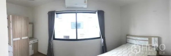Townhouse for rent or sale in Prawet, Bangkok - Furnished bedroom with bed, wardrobe, dressing table and a wide window with air conditioner.