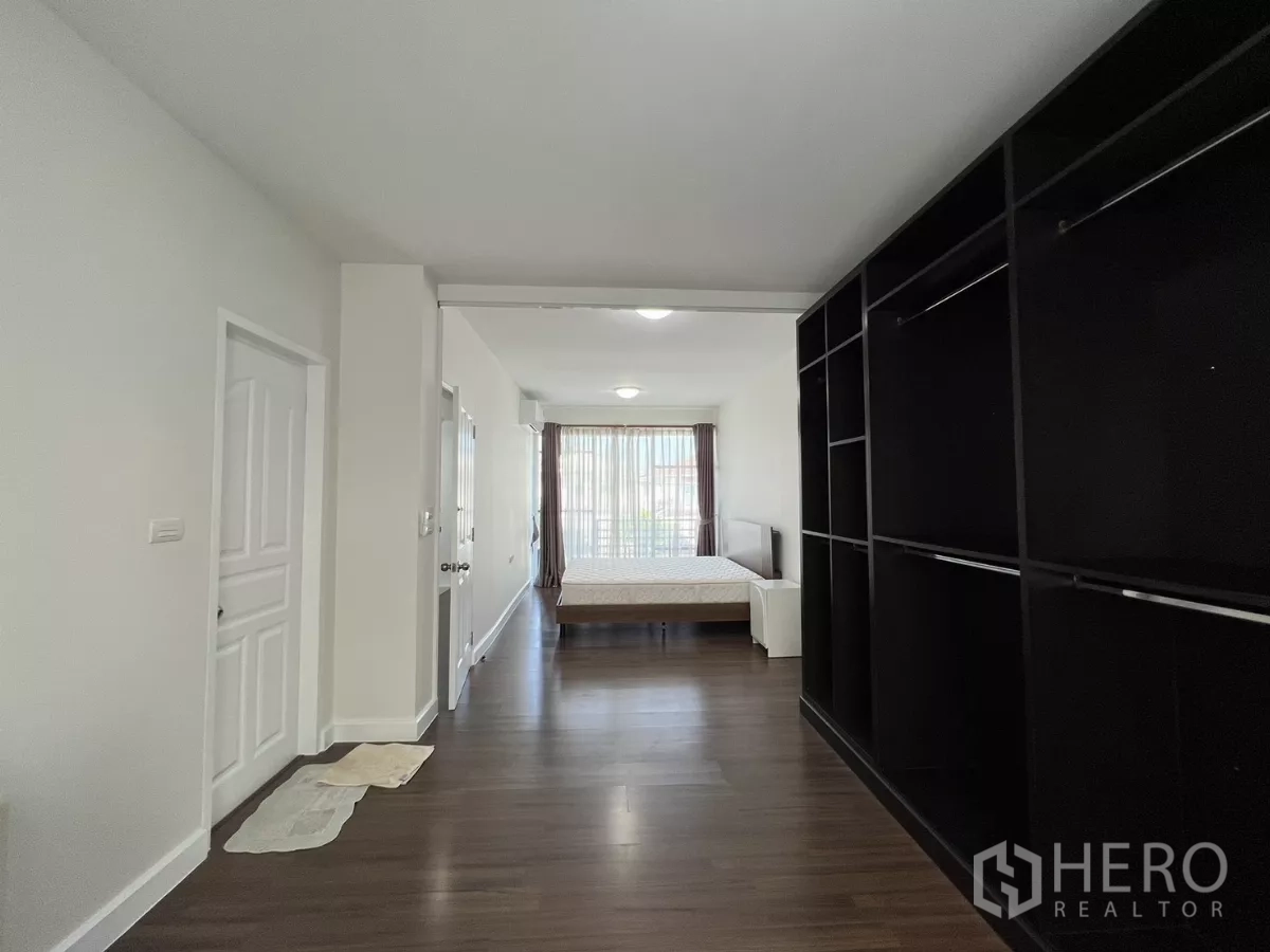 Townhouse for rent in Bang Kapi, Bangkok - Long master suite layout with bed and storage along corridor.
