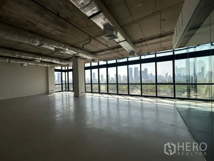 办公空间 出租在Watthana, Bangkok - 开放工作区，通高玻璃、工业风天花与玻璃隔间，享受城市与公园景观。