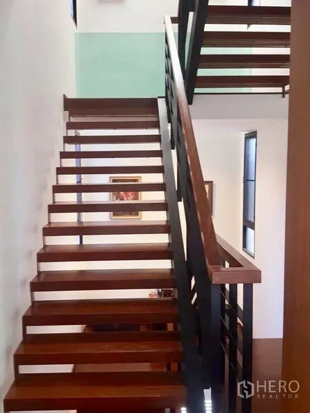 Home Office for rent or sale in Bang Rak, Bangkok - Open-riser wooden staircase with black metal railing and natural light.