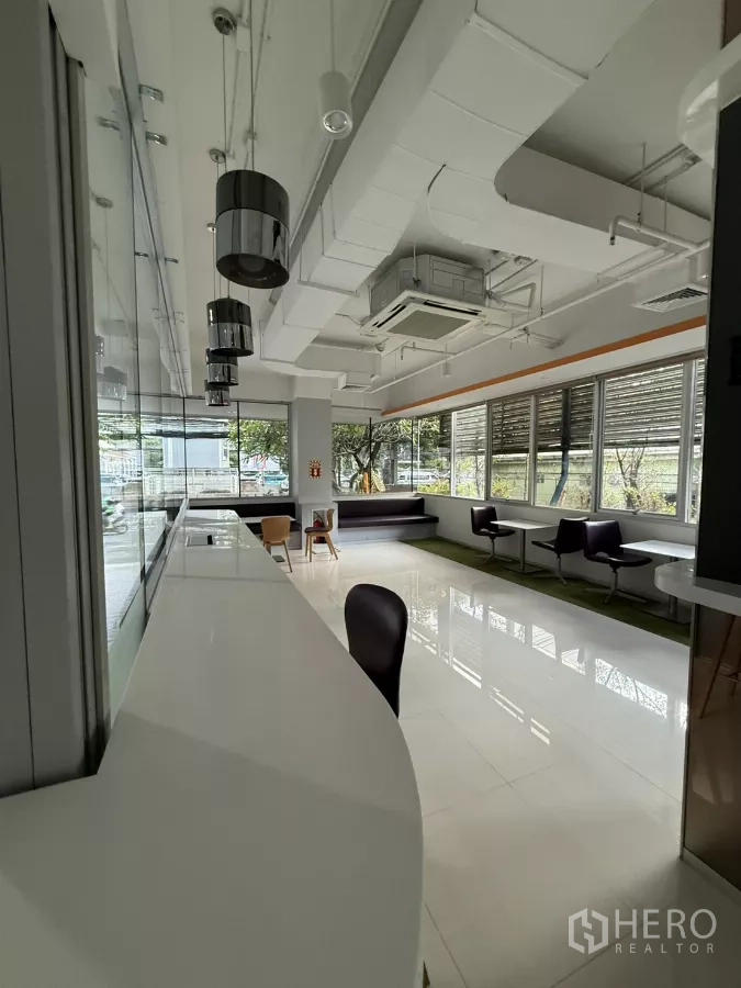 Retail Space for rent in Bang Rak, Bangkok - Long service counter with pendant lights facing wraparound windows and built-in bench seating.