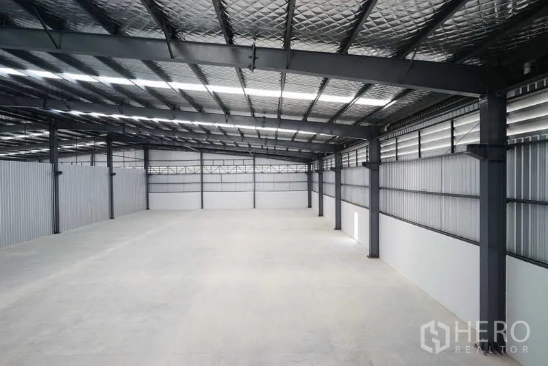 Factory for rent in Chon Buri - Elevated view of production space with insulated roofing and ventilation panels.