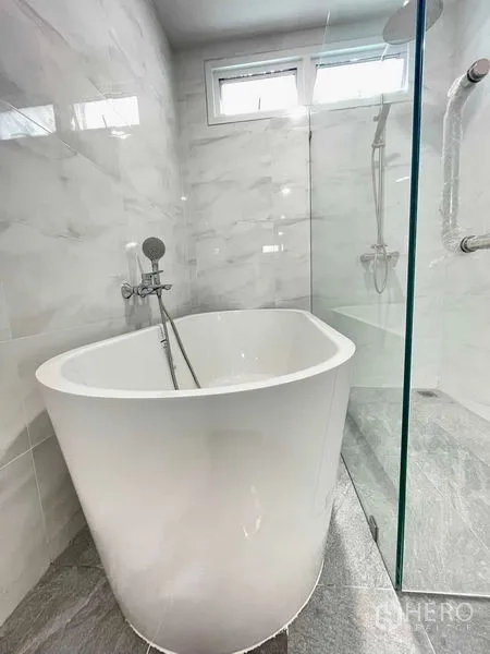 Townhouse for rent or sale in Prawet, Bangkok - Freestanding soaking tub inside a glass shower enclosure with handheld sprayer.