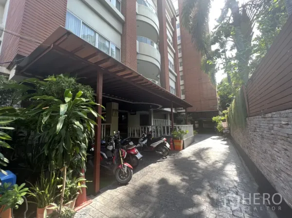 Retail Space for rent in Khlong Toei, Bangkok - Building exterior with covered porch, potted plants and a lane for motorbike parking.