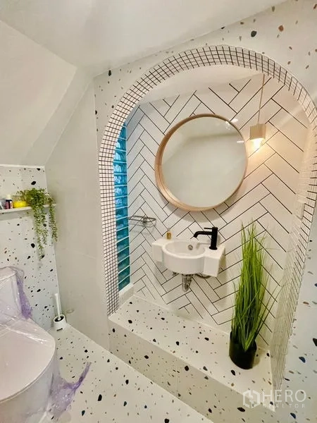 Townhouse for rent in Khlong Toei, Bangkok - Statement bathroom with arched niche, round mirror, terrazzo tiles and greenery.