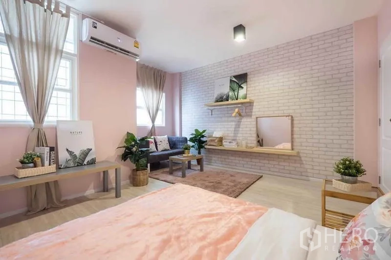 独立式住宅 出租在Khlong Toei, Bangkok - 宽敞粉色卧室，白砖特色墙，沙发座和带镜搁板。