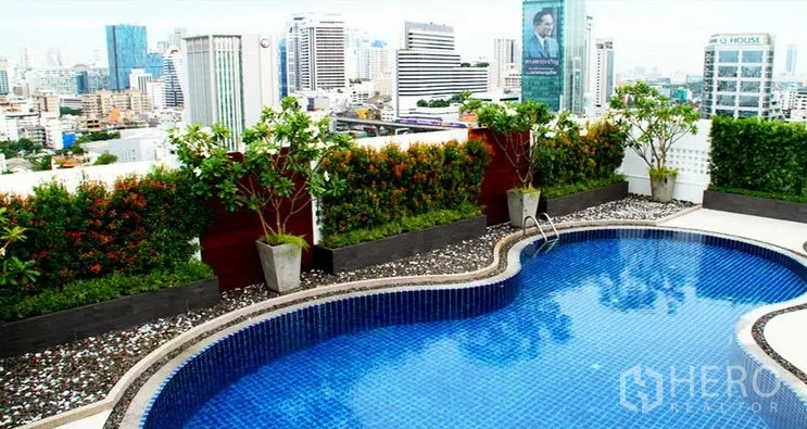 Condominium for rent in Pathum Wan, Bangkok - Rooftop swimming pool with landscaped planters and Bangkok skyline views.