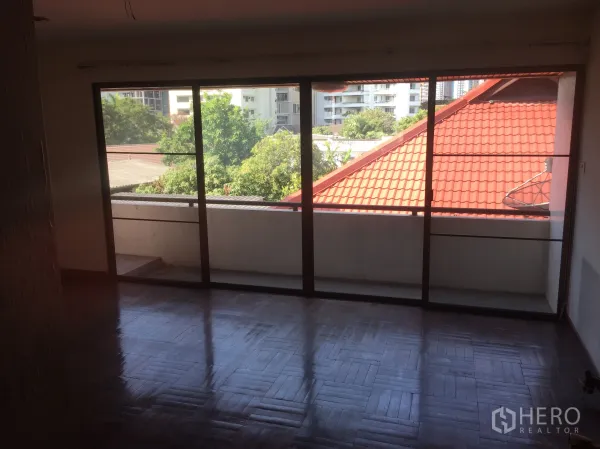 สำนักงานที่บ้าน ขายในWatthana, Bangkok - ห้องติดระเบียง ประตูกระจกเต็มบาน มุมมองหลังคากระเบื้องสีแดงและต้นไม้.