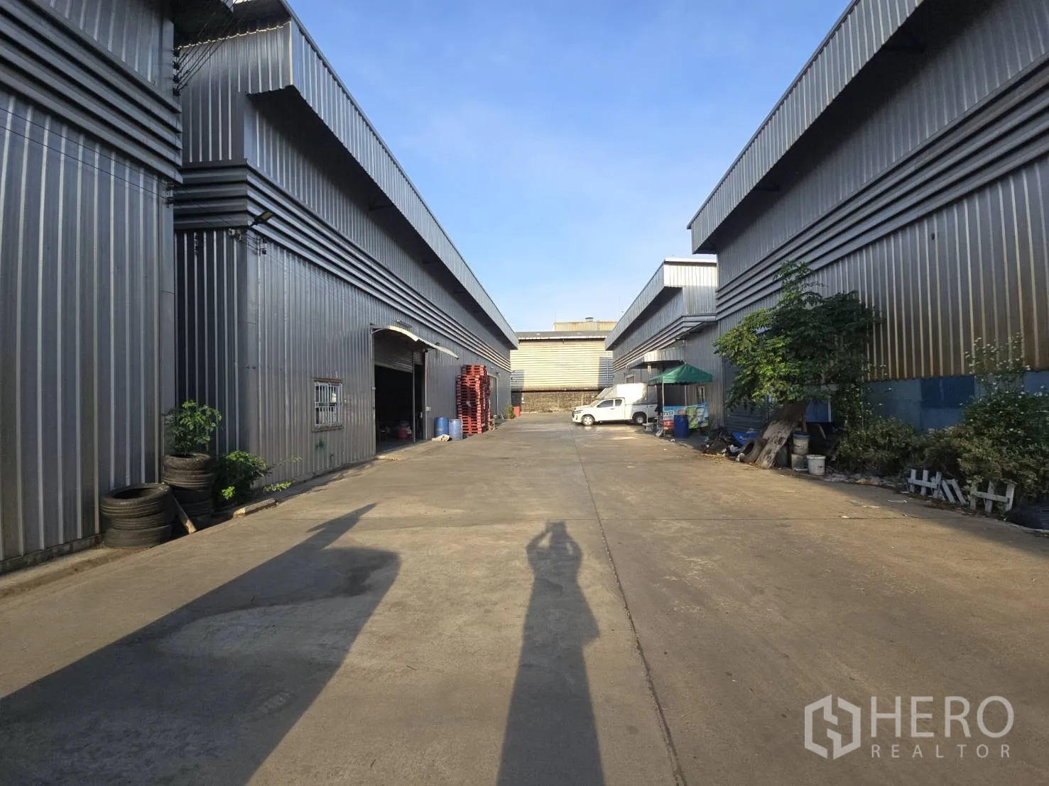 Warehouse for rent in Bang Phli, Samut Prakan - Exterior lane between warehouse buildings with truck access and loading areas.