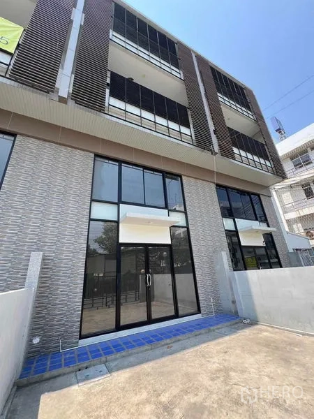 Home Office for rent in Bang Kapi, Bangkok - Close-up of the ground-floor glass storefront and tiled entry of the home office building.