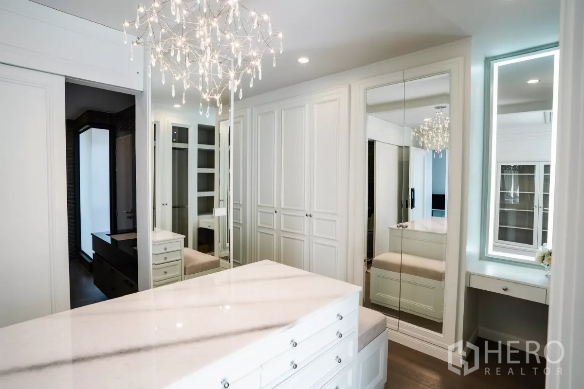 Detached House for rent or sale in Bang Kapi, Bangkok - Spacious walk-in closet with island dresser, mirrored cabinets and designer lighting.