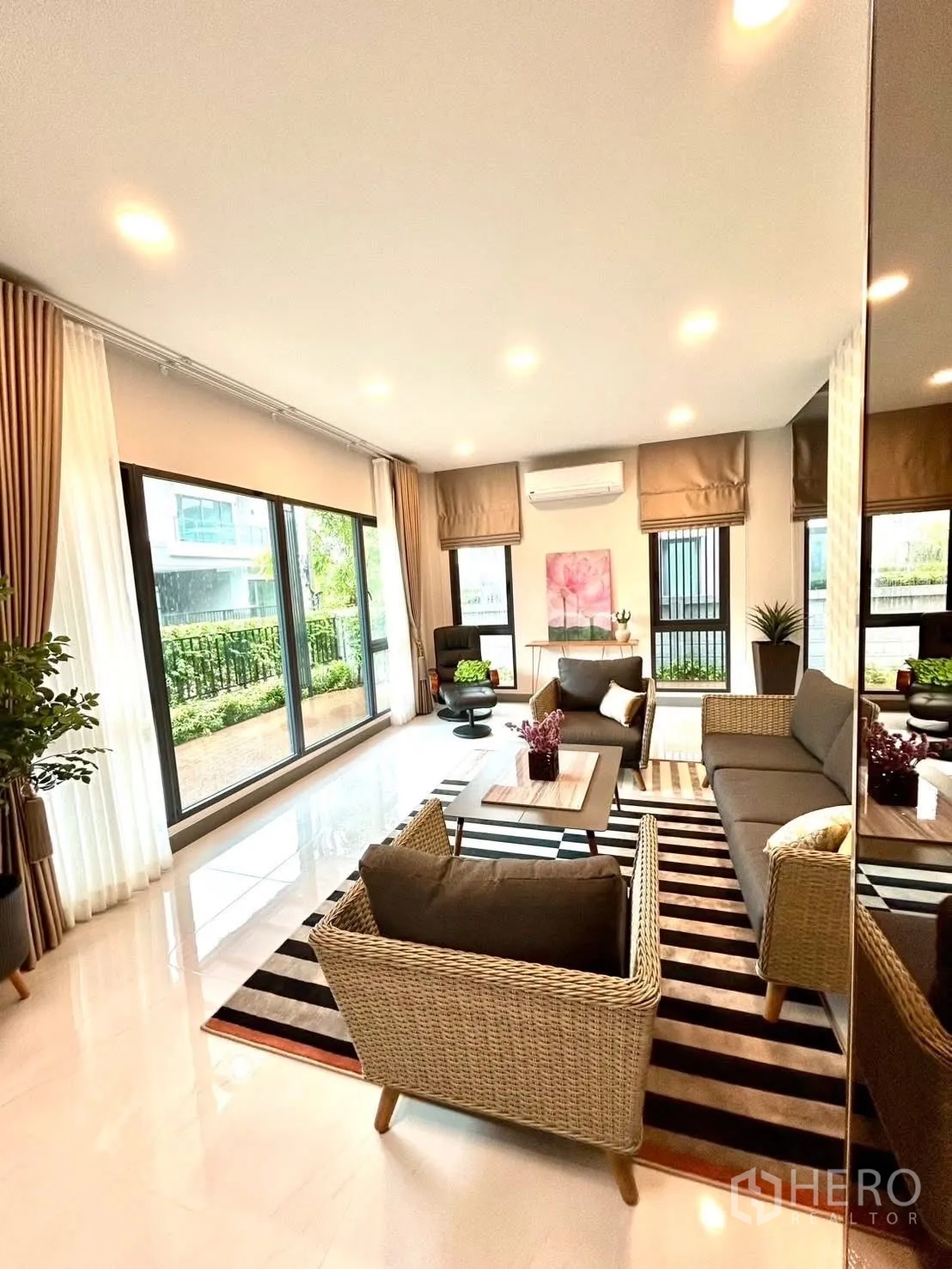 Detached House for rent in Bang Phli, Samut Prakan - Sunlit sitting room with wicker seating, striped rug, and garden views.