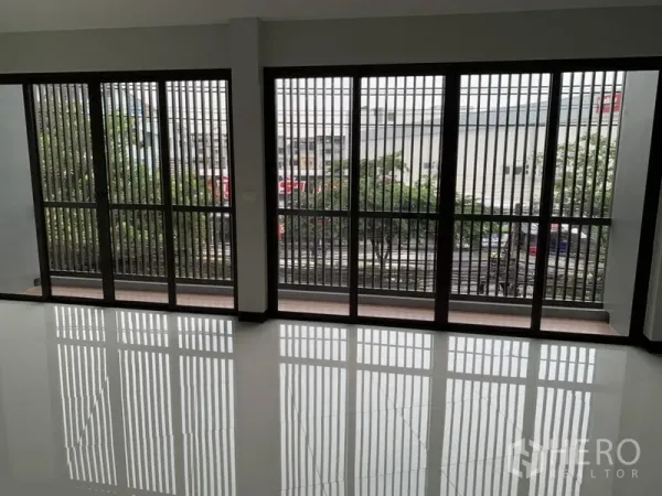 Shophouse for rent in Suan Luang, Bangkok - Floor-to-ceiling sliding glass windows with metal grilles overlooking the street.