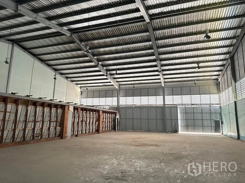 货栈 出租在Lam Luk Ka, Pathum Thani - 仓库内部，金属屋架、照明与大型推拉门。