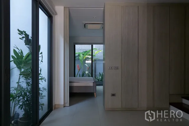 ทาวน์เฮาส์ ให้เช่าในWatthana, Bangkok - โถงทางเดินกระจกสไลด์เปิดสู่คอร์ตยาร์ดไปยังห้องนอน