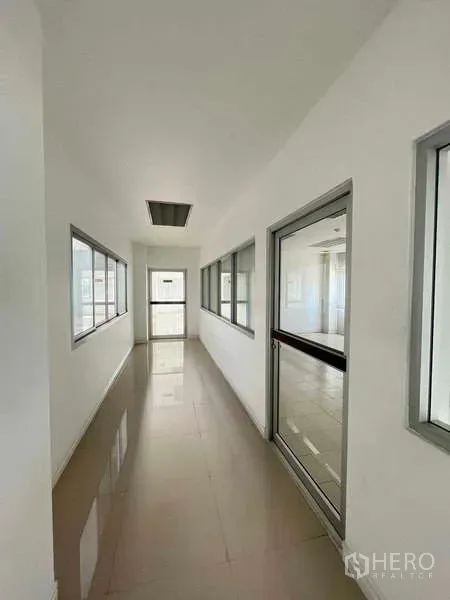Warehouse for rent in Lat Krabang, Bangkok - Bright corridor with windows and a glass door in the warehouse office section.