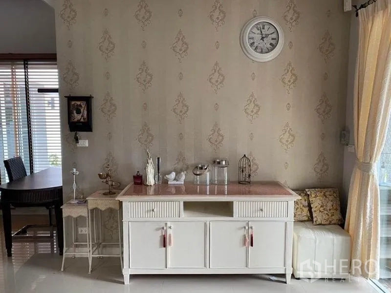 Detached House for rent or sale in Prawet, Bangkok - Interior corner with vintage-style console, clock, and soft drapes.