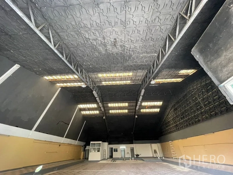 Warehouse for rent in Sam Phran, Nakhon Pathom - Spacious warehouse interior with high steel-truss ceiling and skylight panels.