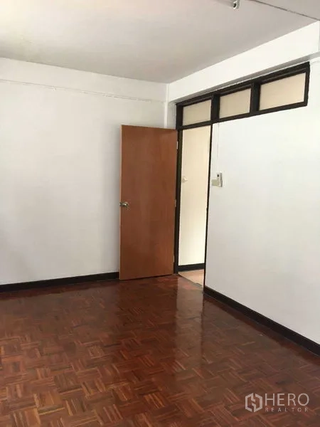 Townhouse for rent in Phra Khanong, Bangkok - Bedroom corner with parquet floor and a wooden door.