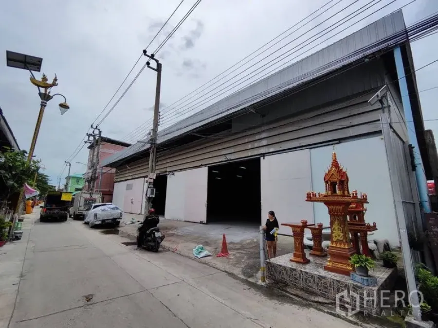 Warehouse for rent in Bang Phli, Samut Prakan - Warehouse entrance on a local street with wide doors and forecourt space.