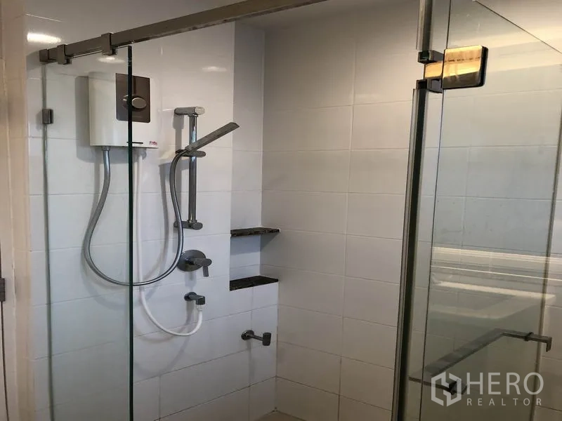 Detached House for rent in Bang Kapi, Bangkok - Second bathroom with glass shower, white tiled walls and water heater.