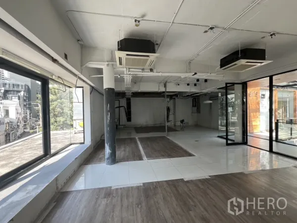 Retail Space for rent - Spacious shop floor with mixed tile and wood-look flooring, glass door and city views.