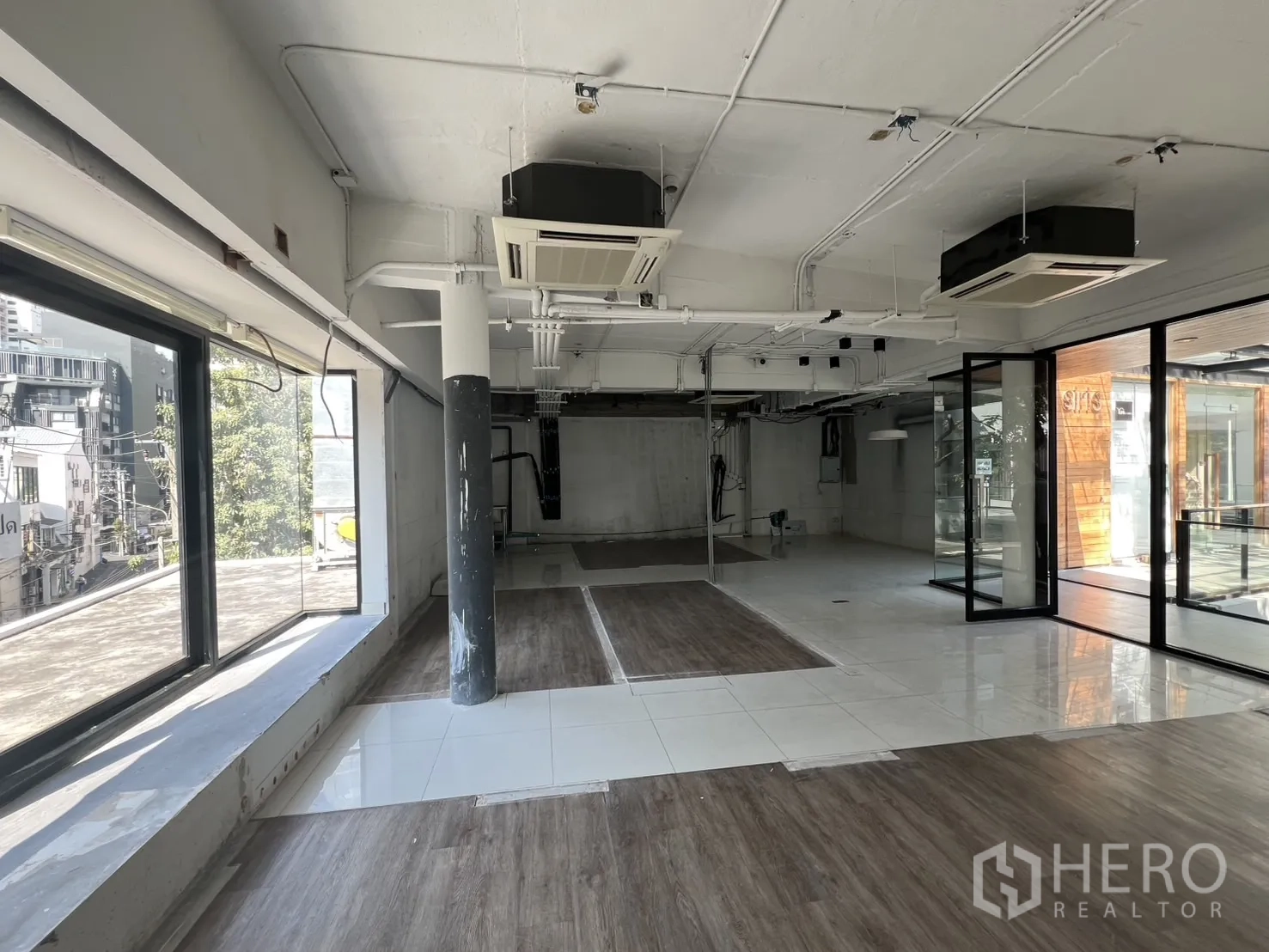 Retail Space for rent - Spacious shop floor with mixed tile and wood-look flooring, glass door and city views.