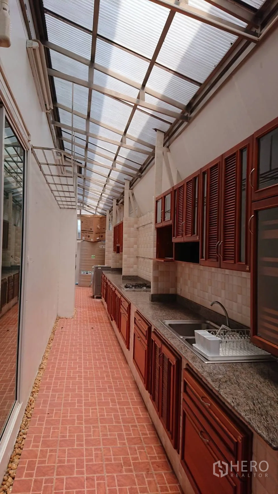 Detached House for rent in Mueang Samut Prakan, Samut Prakan - Covered Thai kitchen with long granite counters, gas hob and terracotta floor tiles.