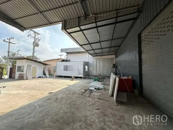 Warehouse for rent in Khlong Luang, Pathum Thani - Covered loading area with roll-up doors and open concrete yard.