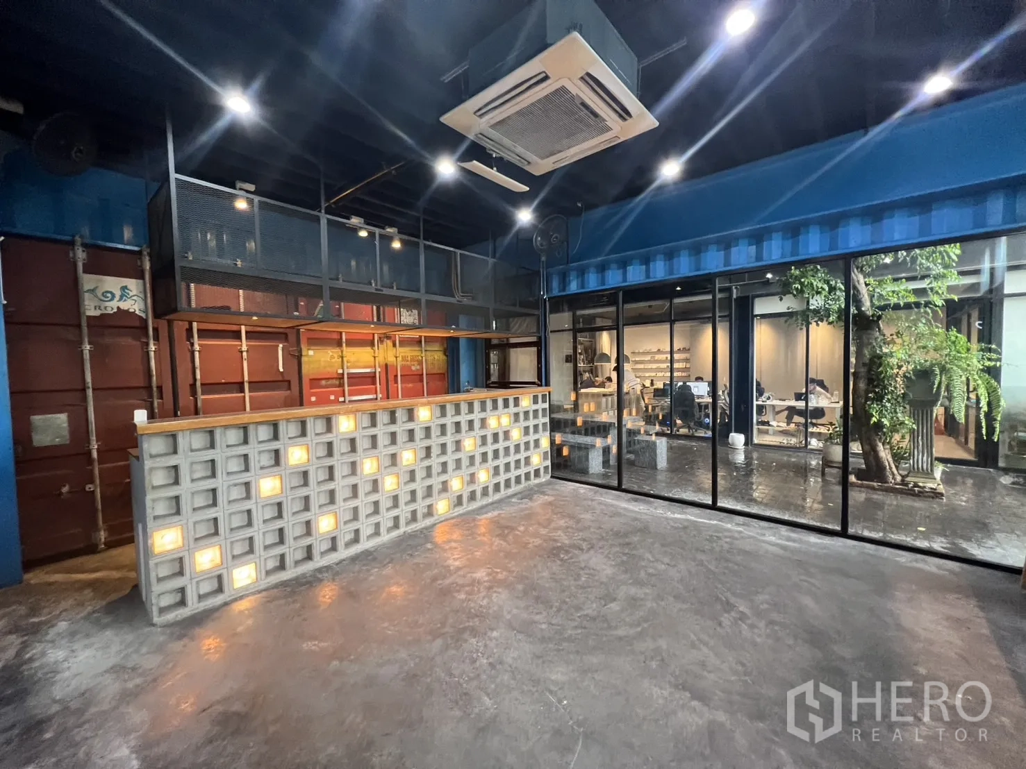 Retail Space for rent - Industrial-style retail interior with illuminated glass-block counter, polished concrete floor, full glass wall and ceiling cassette AC near Ekkamai.