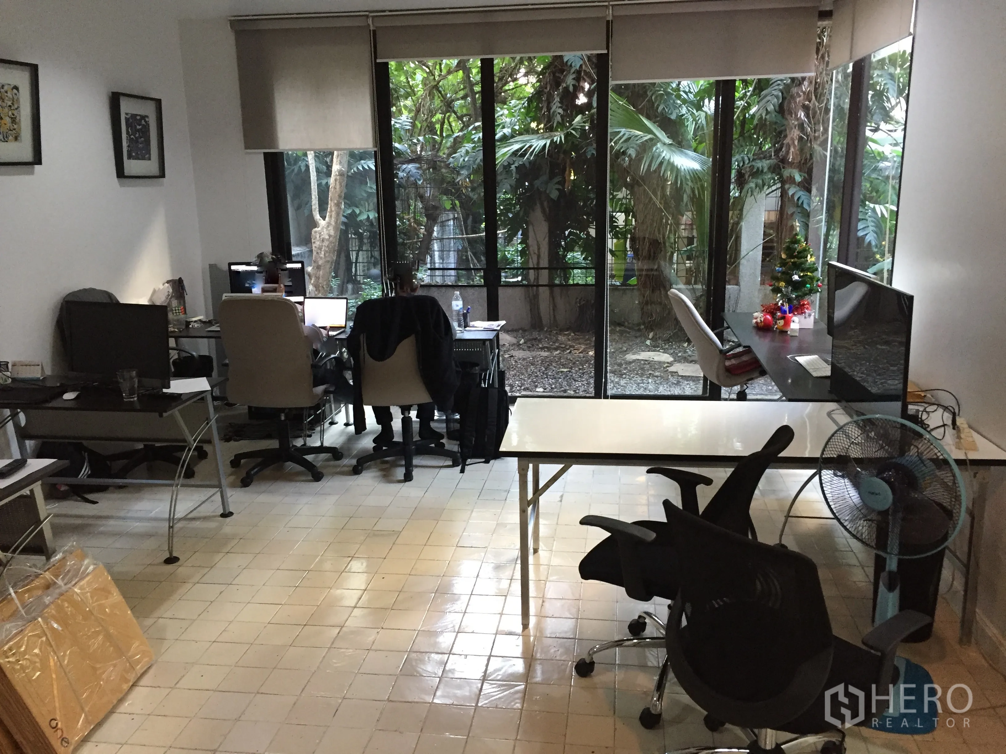 联排别墅 出租在Watthana, Bangkok - 底层起居/办公区，通顶落地窗面向花园，瓷砖地面与多功能书桌