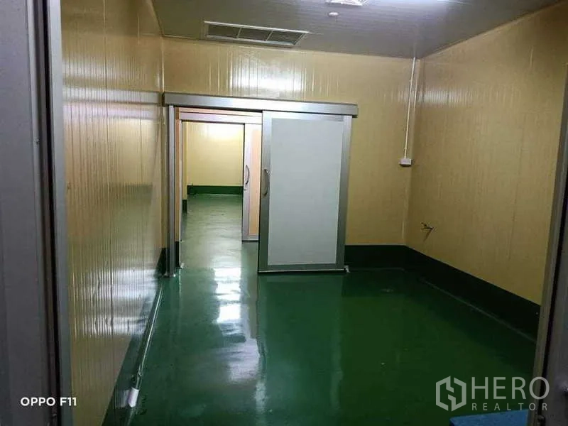 Warehouse for rent or sale in Mueang Samut Sakhon, Samut Sakhon - Clean corridor leading to a sliding door and utility access.