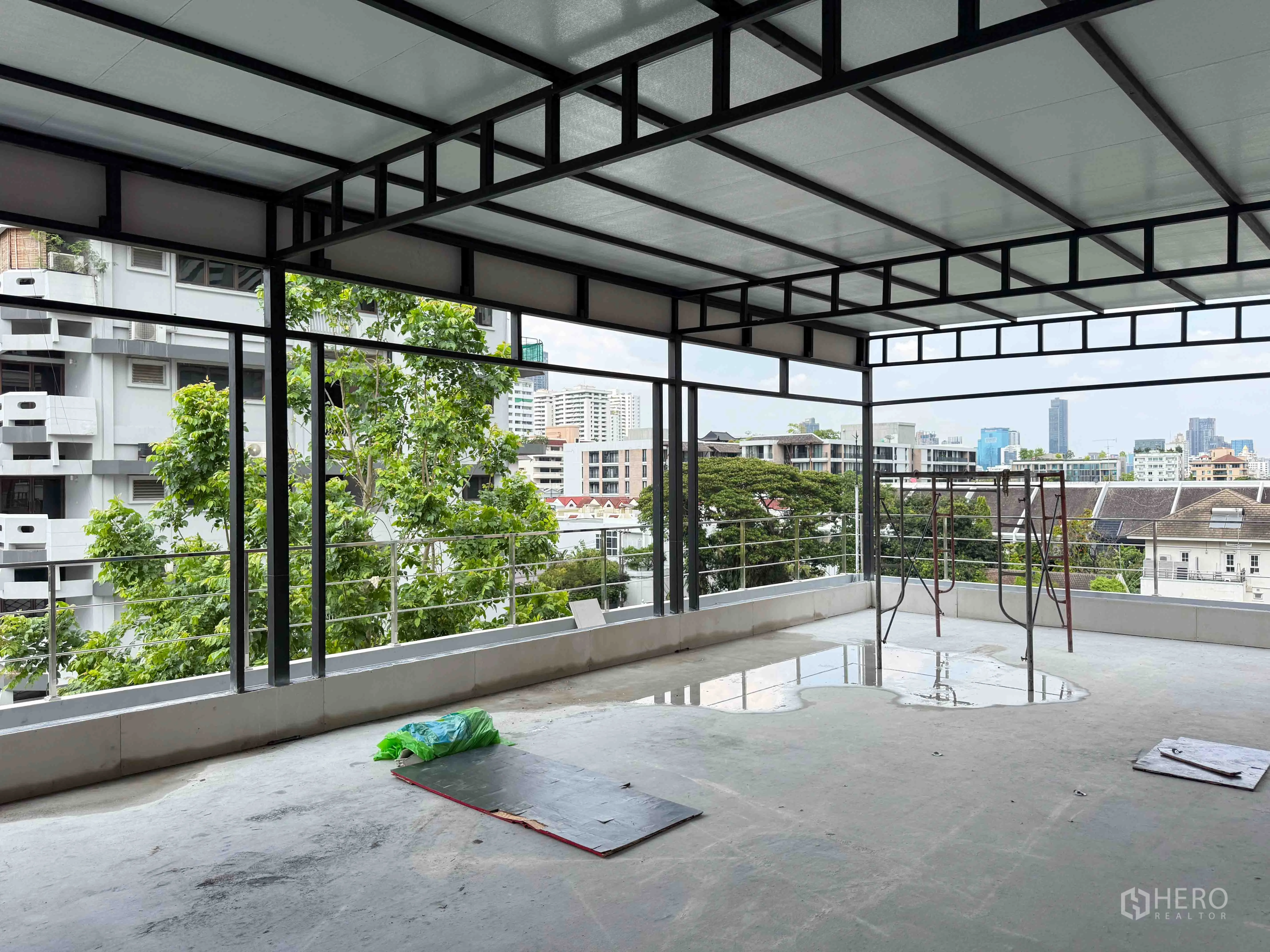พื้นที่ขายของ for rent in Watthana, Bangkok - ชั้นระเบียงกึ่งเปิดโล่งโครงเหล็ก มองเห็นต้นไม้และวิวเมือง.