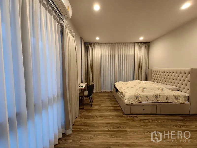 Detached House for rent in Bang Kapi, Bangkok - Spacious master bedroom with wood flooring and large curtained windows