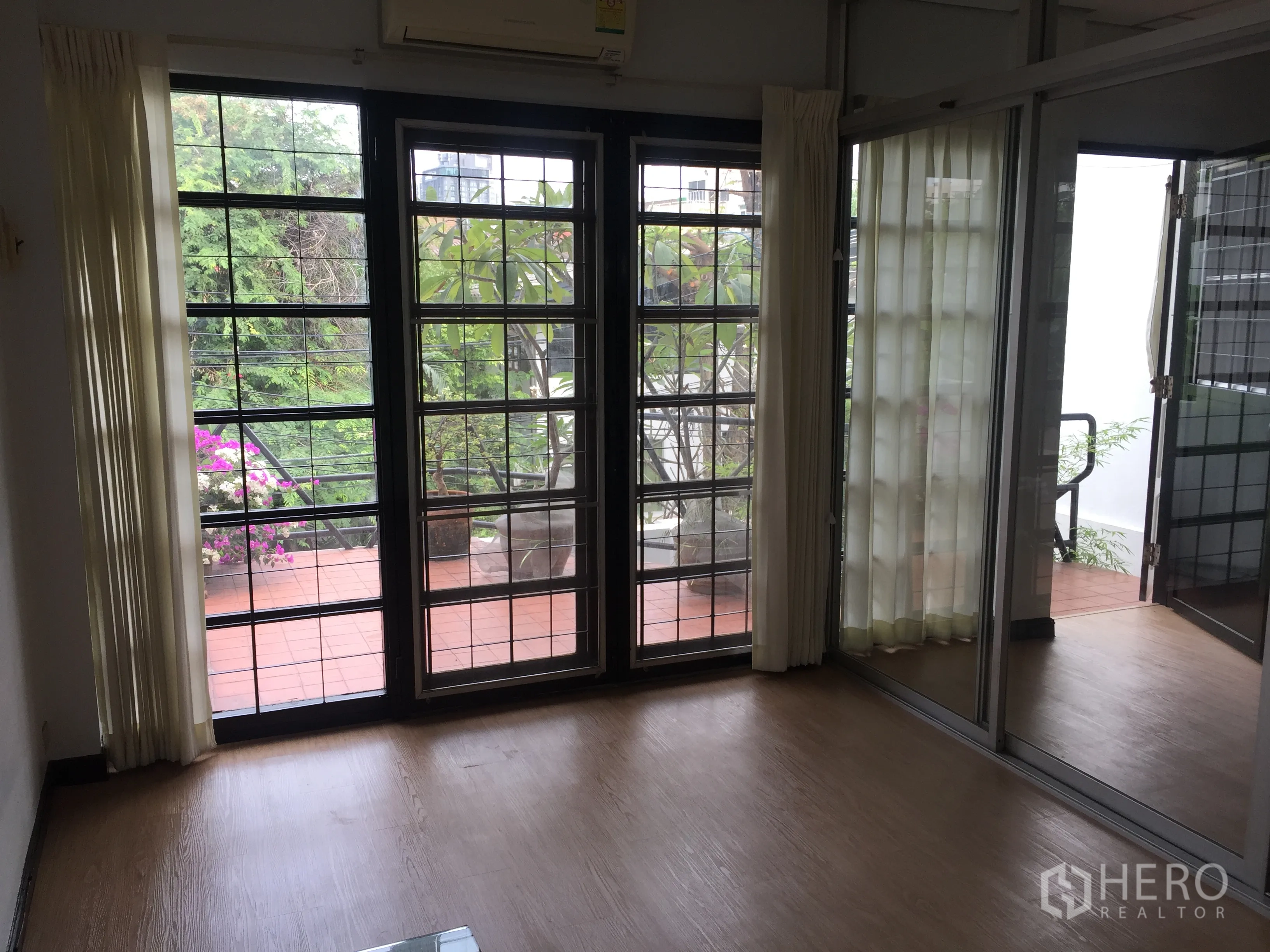 联排别墅 出租在Khlong Toei, Bangkok - 客厅落地推拉门通往绿意露台。
