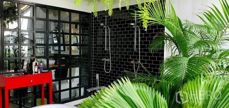 Townhouse for rent in Khlong Toei, Bangkok - Outdoor terrace bathroom with black tile twin rain showers, glass-block wall, red vanity and lush plants.